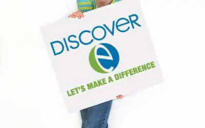 a middle school girl holds a sign with 'discoverE let's make a difference'