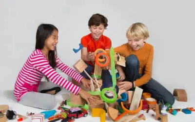 one girl and two boy middle schoolers play and push over block pile
