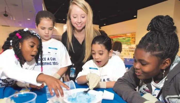 Four Girls and their Role Model do a hands-on activity.