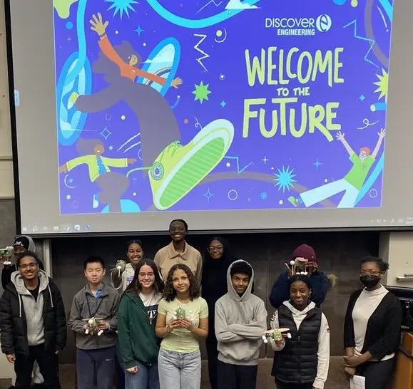 girls putting together a project with the DiscoverE logo and mission: Transform a Student's Future: Introduce them to engineering and tech