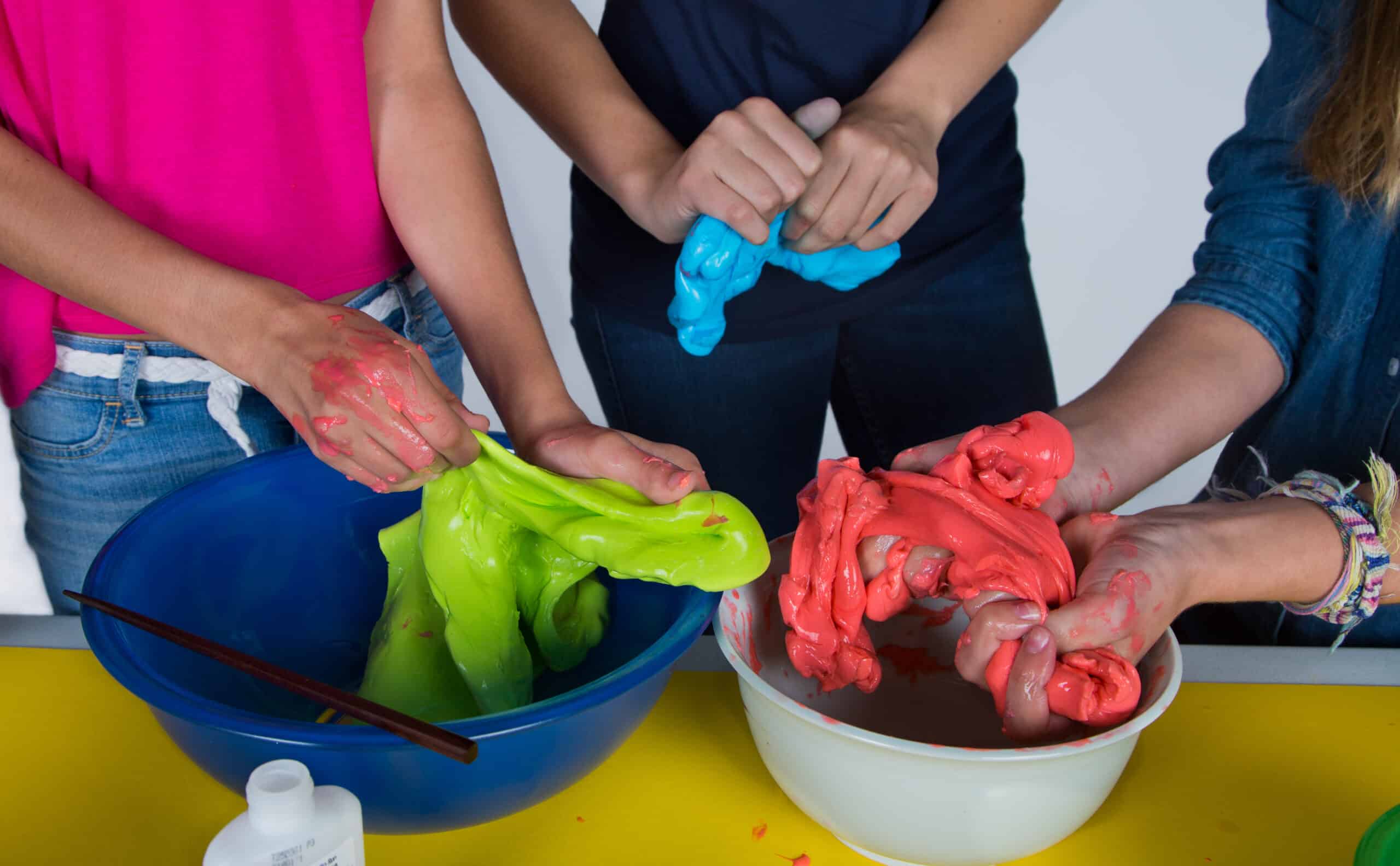 three pairs of hands test and explore three different colors of gak