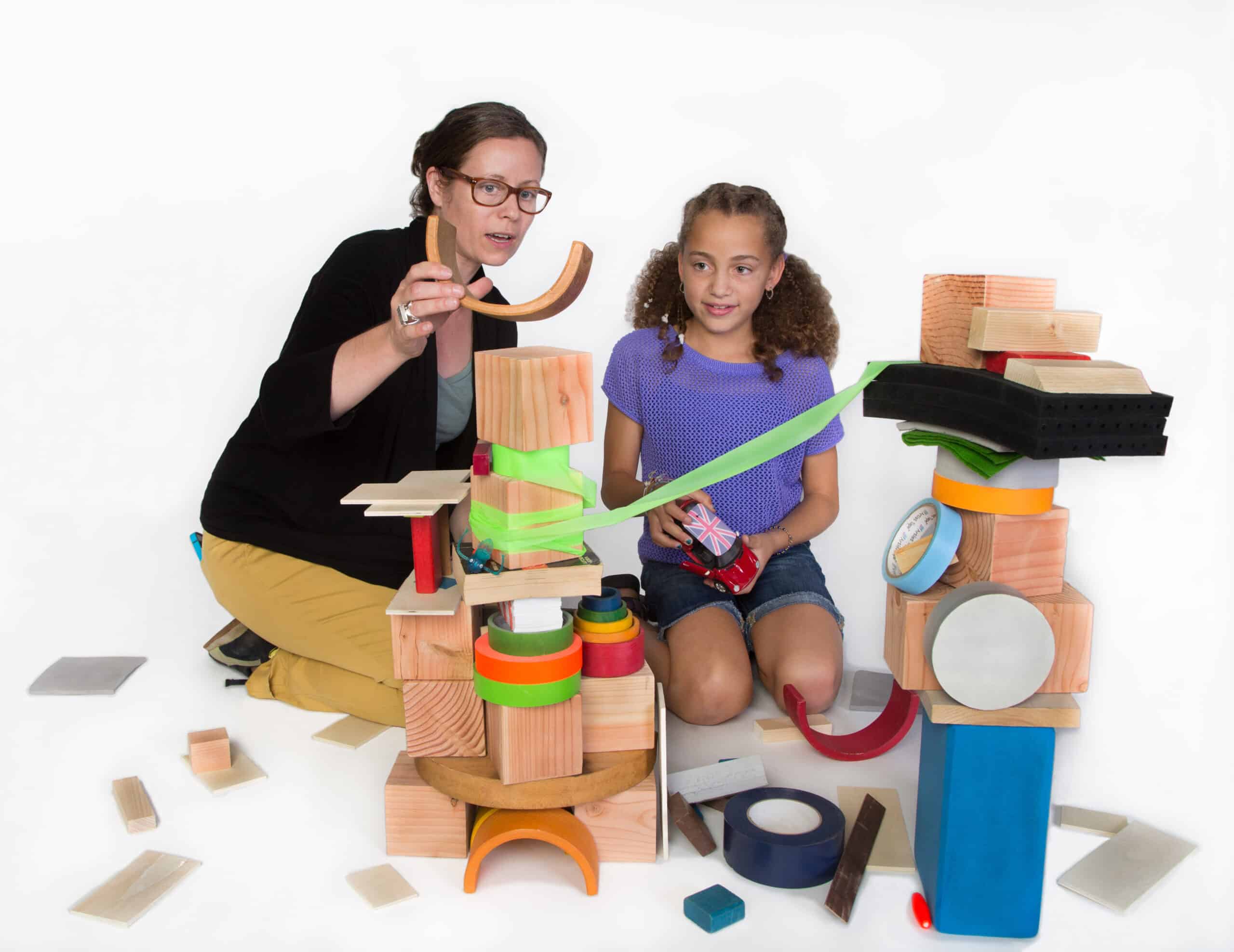 engineer and young girl build a tower out of assorted material for discoverE activity
