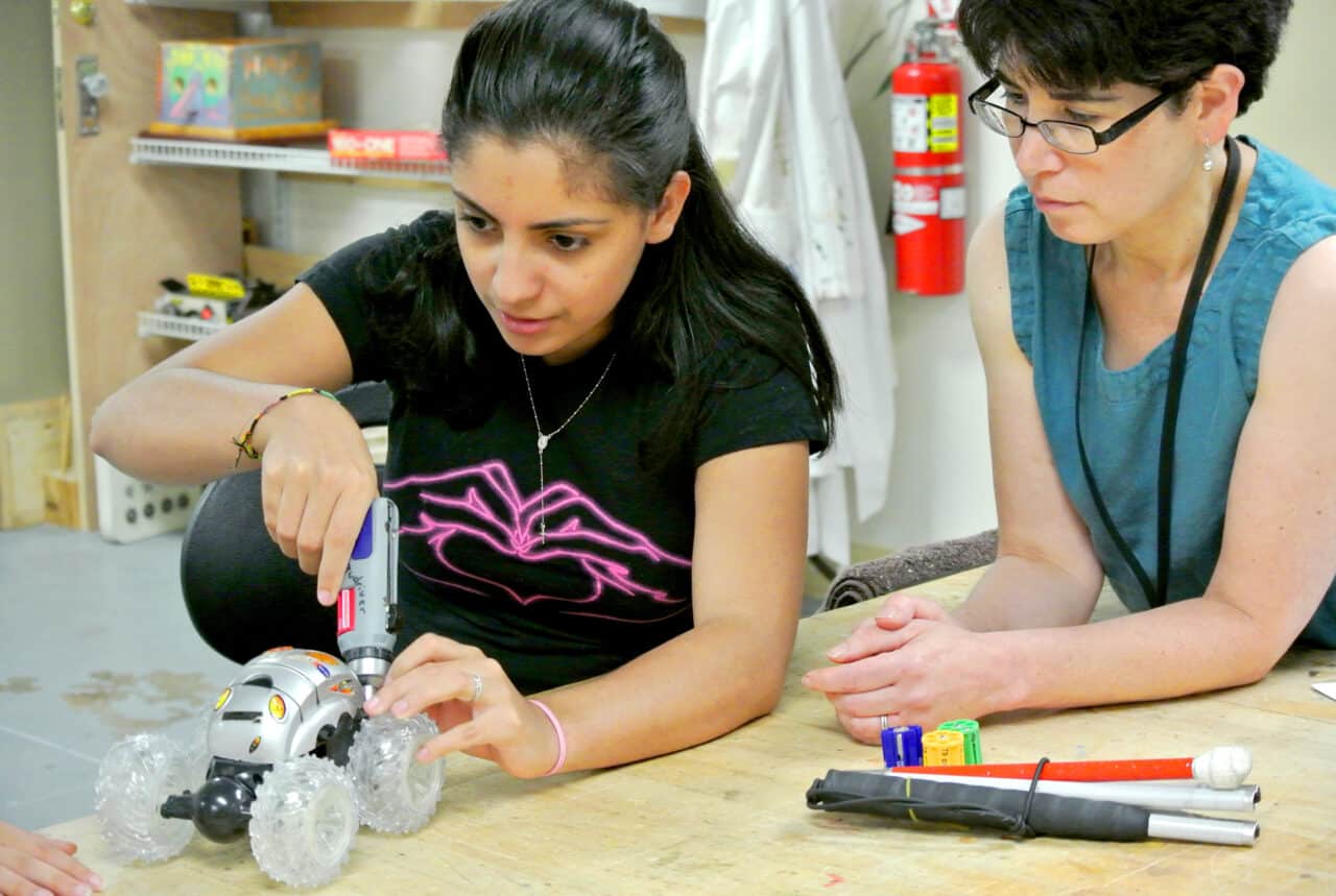 Visuallyimpaired Girl With Teacher Working on Vehicle DiscoverE